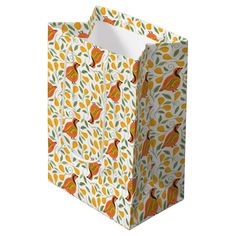 an orange and white patterned shopping bag with birds on the front, sitting against a white background