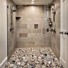 a walk in shower with rocks on the floor