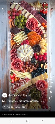 a platter filled with lots of different types of cheese and meats on top of a wooden table