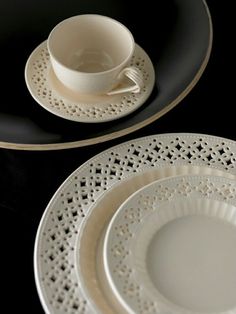 two white plates and one black plate with an empty cup on the side, sitting next to each other