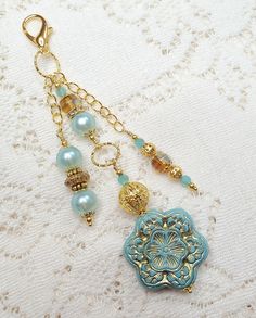 a close up of a key chain on a lace table cloth with beads and charms