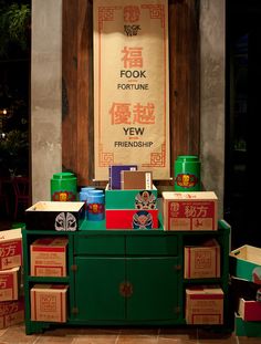 a green cabinet with boxes on it and a sign in the background that says fook fortune yew