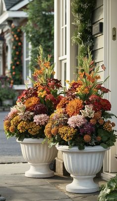 two large white vases filled with colorful flowers