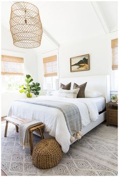 a bedroom with white walls and wooden windows