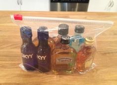 several bottles of alcohol in a clear plastic bag on a wooden table with a new york sticker next to it