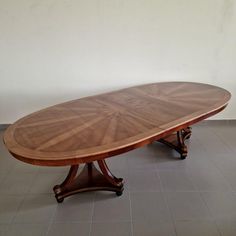 an oval wooden table with two leaves on each end