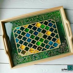 an intricately designed wooden tray with green and yellow tiles