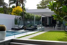 a modern house with a pool in the middle and green grass on the ground next to it