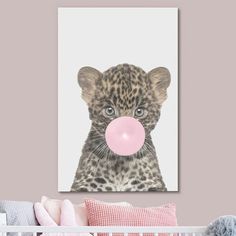 a baby leopard with bubble gum in its mouth on a pink wall above a crib