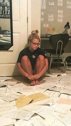 a woman sitting on the floor surrounded by papers