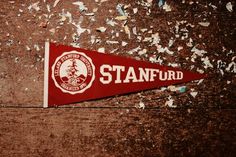 a red pennant with the stanford logo on it surrounded by confetti and shredded paper