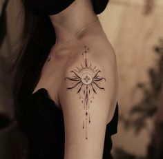 a woman with a sun tattoo on her shoulder