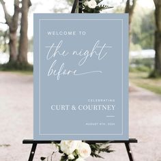 a welcome sign with white flowers on it and the words, the night before is written in curs & coutney