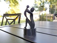 a metal sculpture sitting on top of a wooden table