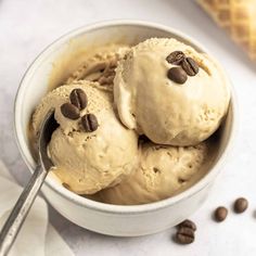 two scoops of ice cream in a bowl with coffee beans