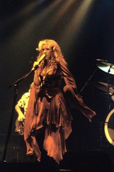 a woman standing on top of a stage holding a microphone