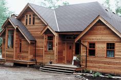 a large wooden house sitting in the middle of a forest