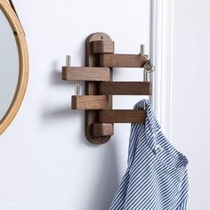 there is a coat rack hanging on the wall next to a mirror and towel holder