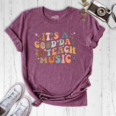 "Looking for the perfect shirt to show off your passion for teaching music? Look no further than our \"It's a Good Day to Teach Music\" shirt! Made with high-quality materials and designed with music teachers in mind, this shirt is the ultimate expression of your love for music education. Crafted for both style and comfort, this shirt features a unique design that's sure to turn heads. The phrase \"It's a Good Day to Teach Music\" is printed in bold letters across the front, making it clear to everyone around you that music education is your passion. And it's not just about the message - this shirt is also incredibly comfortable to wear. Made from a soft and breathable fabric, it's perfect for long days in the classroom or for casual wear on the weekends. So why wait? Show off your love fo Daisy Shirt, Education Shirts, Moon Graphic Tee, Positive Tees, Elementary Music Teacher, Spiritual Shirts, Retirement Shirts, Funny Workout, Inspirational Tshirts