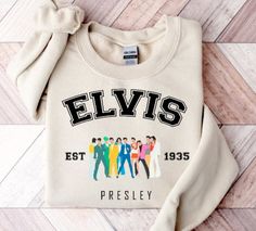 an elvis presley sweatshirt with the band's name on it, sitting on a wooden floor