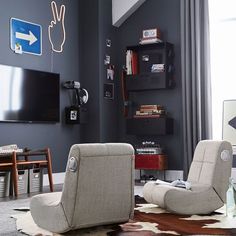 a living room with two recliners and a television on the wall in front of it