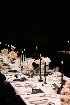 a long table is set with flowers, candles and place settings for an elegant dinner