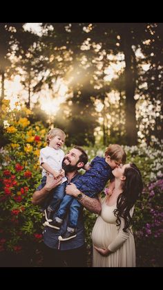 a man, woman and child are posing for a photo in front of some flowers