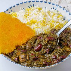 a bowl filled with rice, beans and meat next to a yellow piece of bread