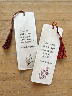 two bookmarks with words on them and tassels attached to the tags that say, i've got one in a world