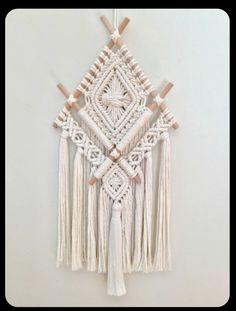 a white wall hanging with tassels on it