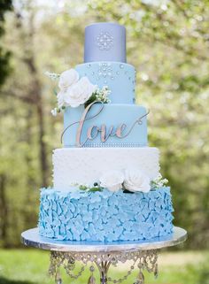 a blue and white wedding cake sitting on top of a table