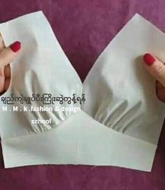 two hands holding white napkins on top of each other in front of a purple background