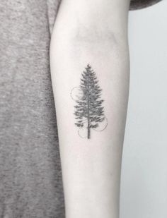 a small pine tree tattoo on the arm