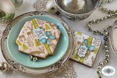 a table topped with plates and silverware covered in frosted cookies next to ornaments