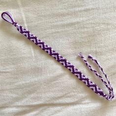 a purple and white lanyard on top of a bed