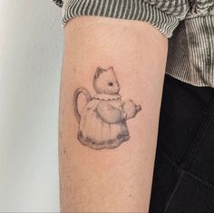 a small cat tattoo on the arm