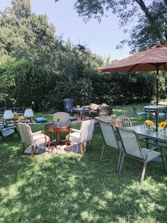 an outdoor table and chairs set up in the grass