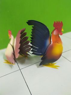 three colorful roosters are standing on a tile floor