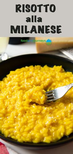 risotto alla milanee in a black bowl with a fork on the side