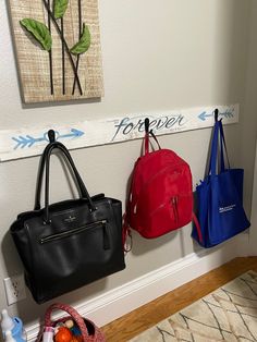 three purses are hanging on the wall