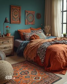 a bedroom with blue walls and orange bedspread, rugs and artwork on the wall