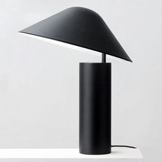 a black table lamp sitting on top of a white surface