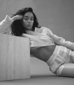 a black and white photo of a woman laying on the floor with her legs crossed