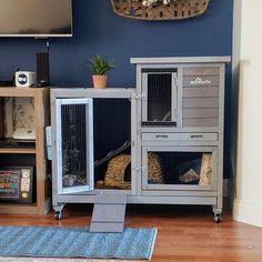 a living room with blue walls and a television on top of the entertainment center in front of a flat screen tv