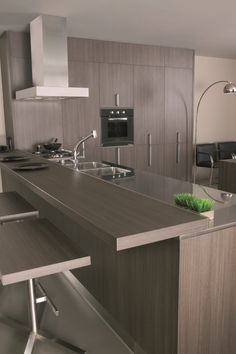 a modern kitchen with stainless steel appliances and counter tops, along with an island in the middle