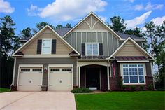 a large house with two garages in front of it