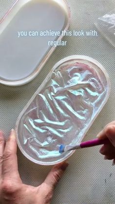 someone is painting the inside of a plastic container