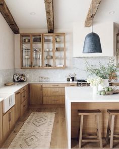 a kitchen with wooden cabinets and white counter tops, along with an area rug on the floor