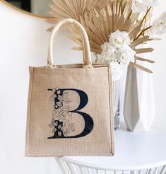 "Floral Monogram Tote Bags make a great gift for bridesmaids or friends over the holidays! Monogrammed burlap bags are customized with a beautiful floral initial of your choice. Each monogram has a vintage \"stamped\" finish - no two are alike. Details This listing is for 1 Monogram Tote Bag with a VINTAGE STAMPED FINISH. Size: 12\" x 12\" with 7.75\" gusset 100% Burlap Fabric with laminated interior LISTING IS FOR Tote Bag ONLY - NO OTHER ITEMS WILL BE SHIPPED. Print is on ONE side ONLY. Be sur Valentine Gift Bags, Shopping Tote Bags, Valentines Gift Bags, Burlap Tote Bags, Burlap Tote, Burlap Bags, Wedding Gift Bags, Monogram Tote Bags, Personalized Logo