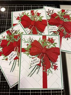 four christmas cards with bows and ribbons on them